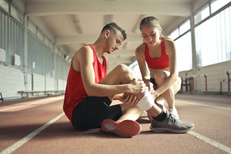 Mujer ayudando a su pareja después de lesionarse con un ejercicio