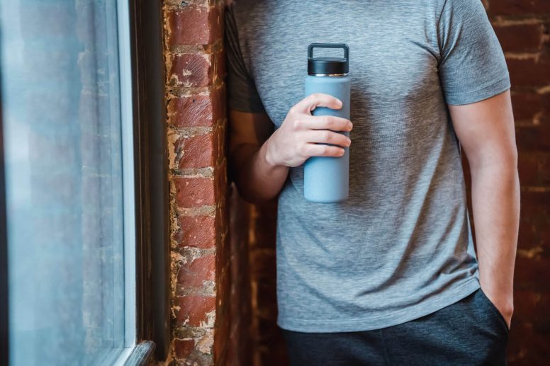 Hombre con termo para tomar sus proteínas en la ventana anabólica