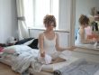 Mujer haciendo meditación mindfulness, vipassana y zen en su cama