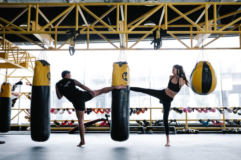 Pareja pateando saco en entrenamiento de kick boxing